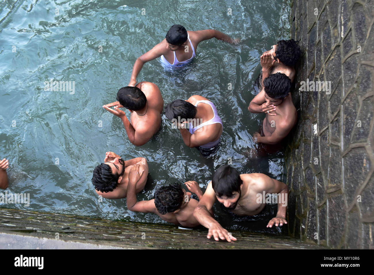 I ragazzi del Kashmir il raffreddamento in acqua in una calda giornata estiva a Srinagar, Indiano Kashmir amministrato. L'onda di calore ha continuato a Srinagar città con mercurio soaring al di sopra di una temperatura normale e nessuna tregua immediata prevista mediante il servizio meteo. La temperatura massima nella città è stata registrata a 34,4 gradi Celsius, 8.1 tacche sopra il normale il lunedì. Foto Stock