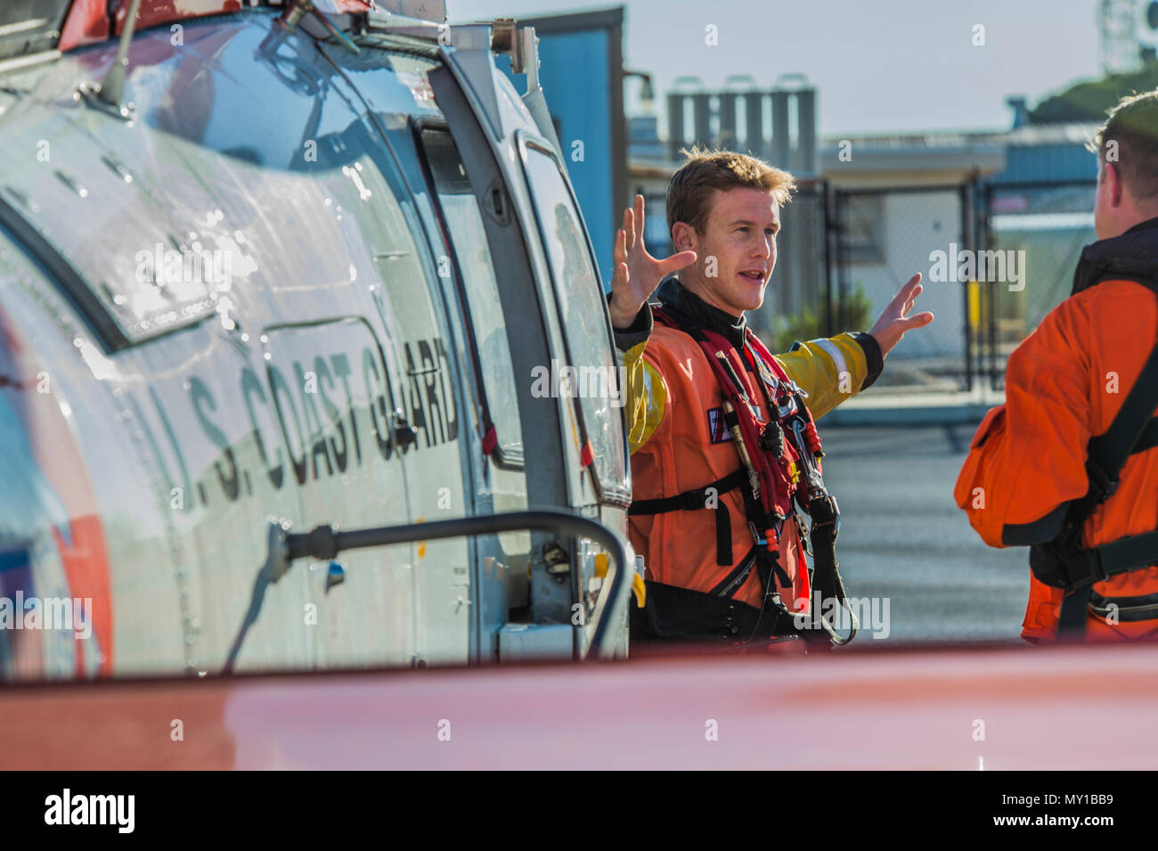 161228-N-UG232-00211 base navale Ventura County Point Mugu, California Aviazione - Tecnico di sopravvivenza di terza classe Richard Hoefle parla al pilota accanto alla loro HH-65 Dolphin a Coast Guard Avanti Base Operativa Point Mugu a bordo di base navale Ventura County, Point Mugu. NBVC Point Mugu supporta anche operazioni del Naval Air Warfare Center Divisione armi. NAWCWD, che ha strutture in Cina lago e Point Mugu, California, esegue l intero spettro delle armi di guerra e di sistemi di ricerca e sviluppo, l'acquisizione, il test e la valutazione ed è leader nella fornitura di innovativi, integrati e warf dominante Foto Stock