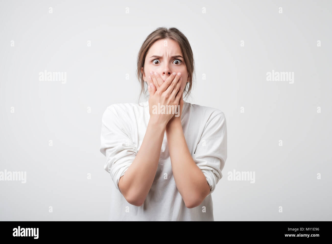 Closeup interessati paura scioccato donna caucasici che copre la bocca Foto Stock