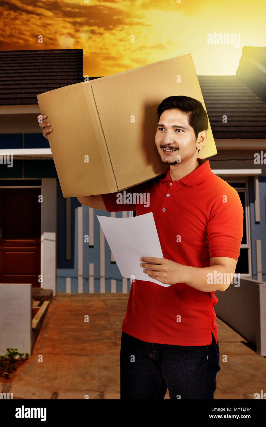 Professional asiatica corriere maschio consegnare il pacchetto a casa del destinatario Foto Stock