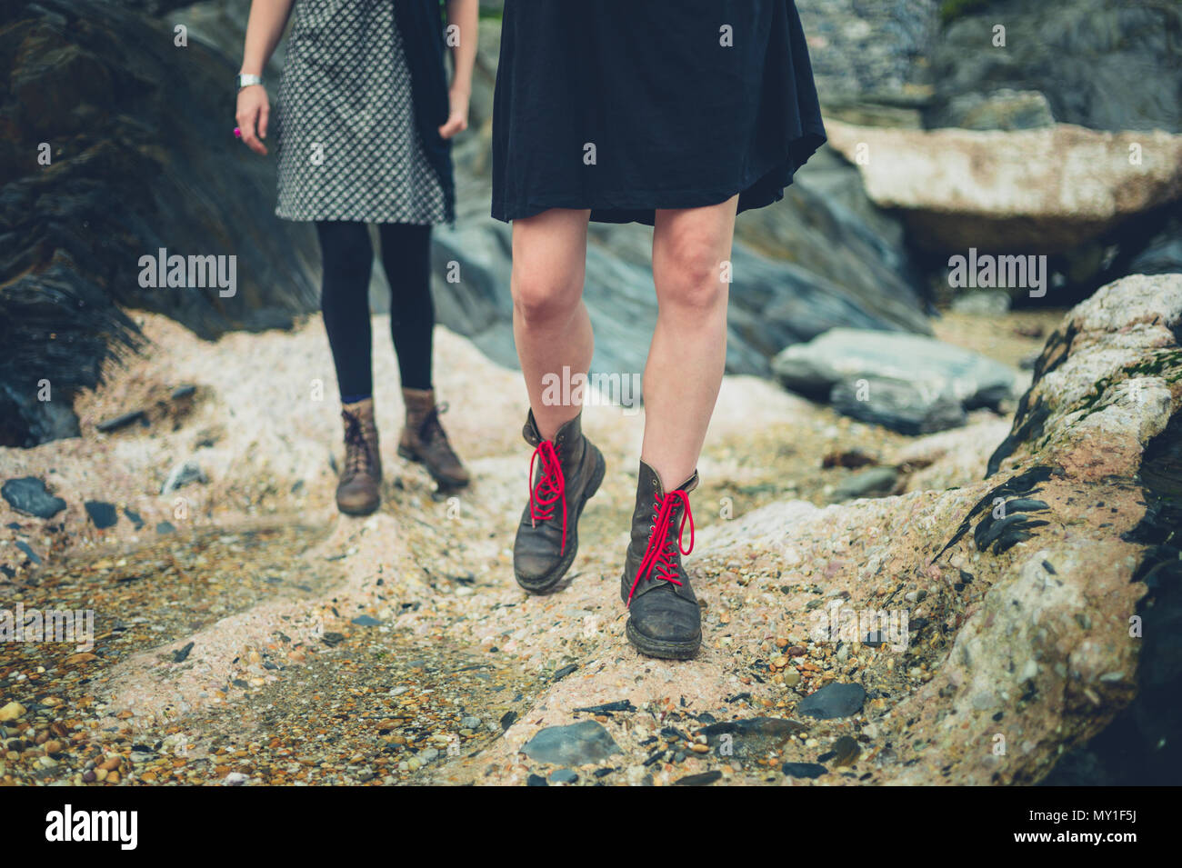 Le gambe e i piedi di due donne di camminare sulla spiaggia Foto Stock