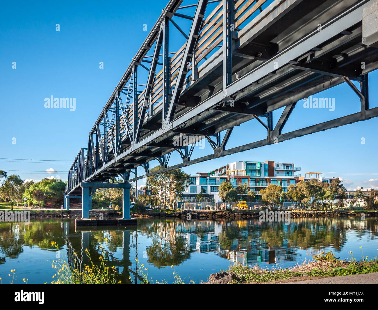 Passerella sul fiume Maribyrnong Footscray di collegamento e di Kensington. Nuovi appartamenti residenziali in costruzione sul lungofiume. Foto Stock