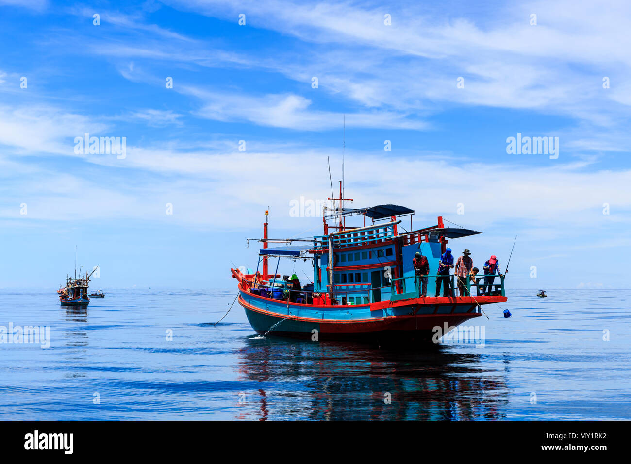 Barca da pesca galleggianti in mare. Il bellissimo luminoso cielo blu e blu acqua in un giorno chiaro. Foto Stock