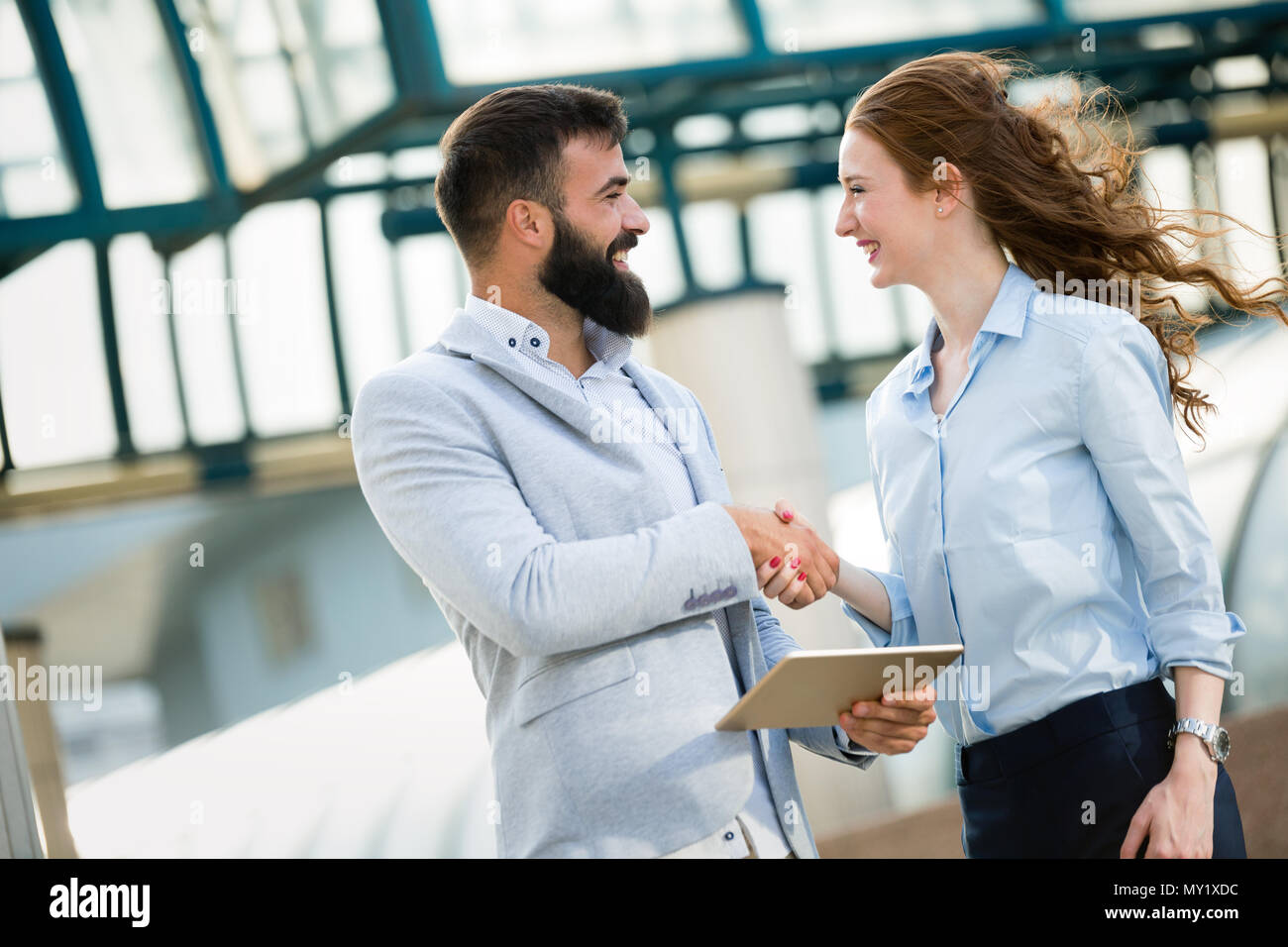 Business e concetto di ufficio. Imprenditore e imprenditrice stringono le mani Foto Stock