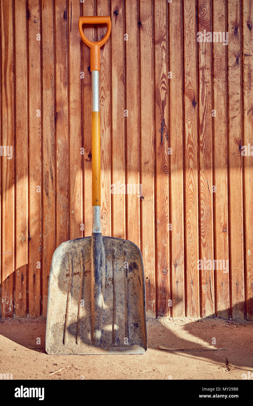 Grande vecchio pala addossato alla parete in legno di una casa di campagna Foto Stock