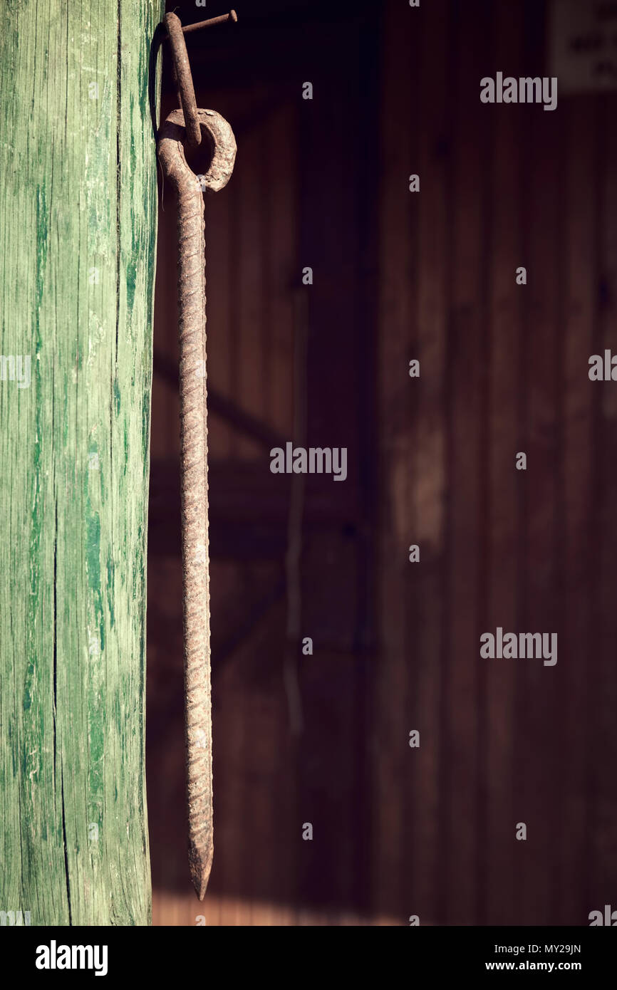 Vintage rusty bullone a occhio appeso da una trave di legno Foto Stock