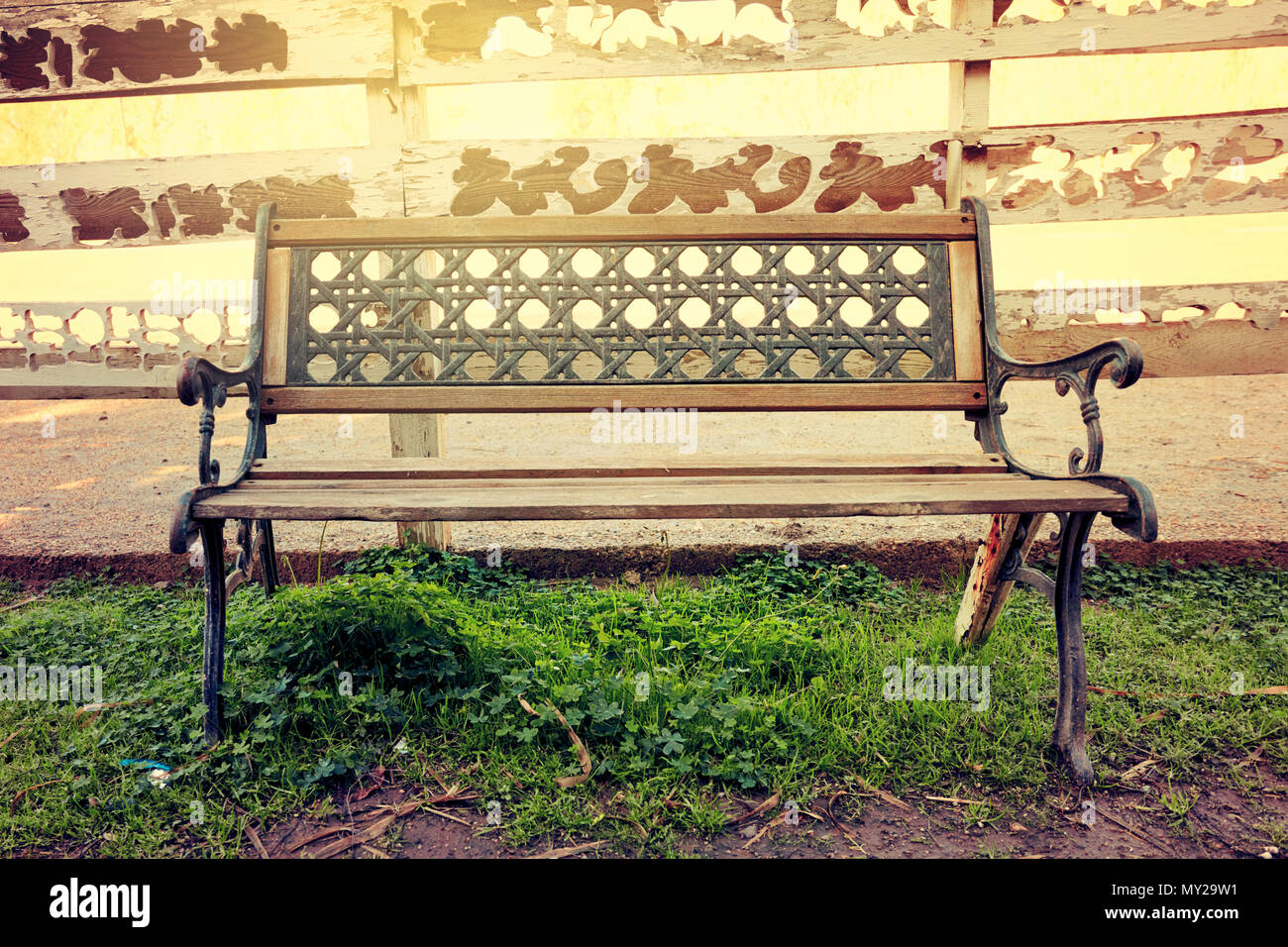 Vintage in legno ferro battuto banco nella parte anteriore delle spalle di un maneggio in una zona rurale Foto Stock