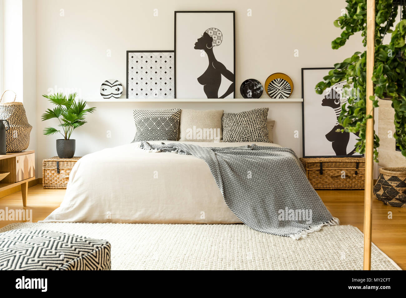 I poster e le piastre modellato sopra il letto in camera da letto scandi  Interni con impianti e pouf Foto stock - Alamy