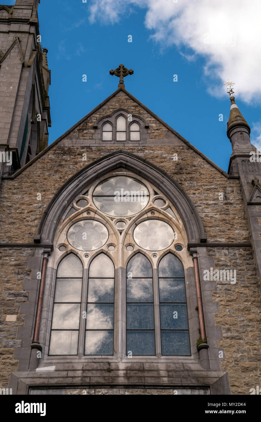 Un vecchio ornato chiesa woindow con riflessioni di cloud Foto Stock