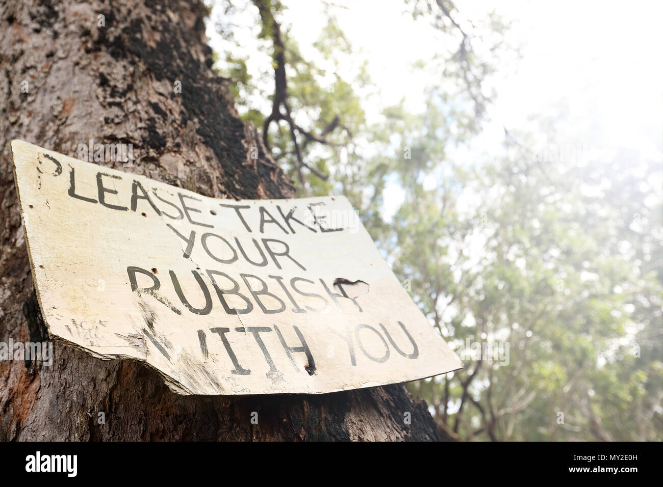 Più viste di un vecchio segno usurata post di istruire i partecipanti i pescatori bush camminatori escursionisti ad assumersi la responsabilità per la rimozione di tutti i rifiuti nel cestino della spazzatura Foto Stock