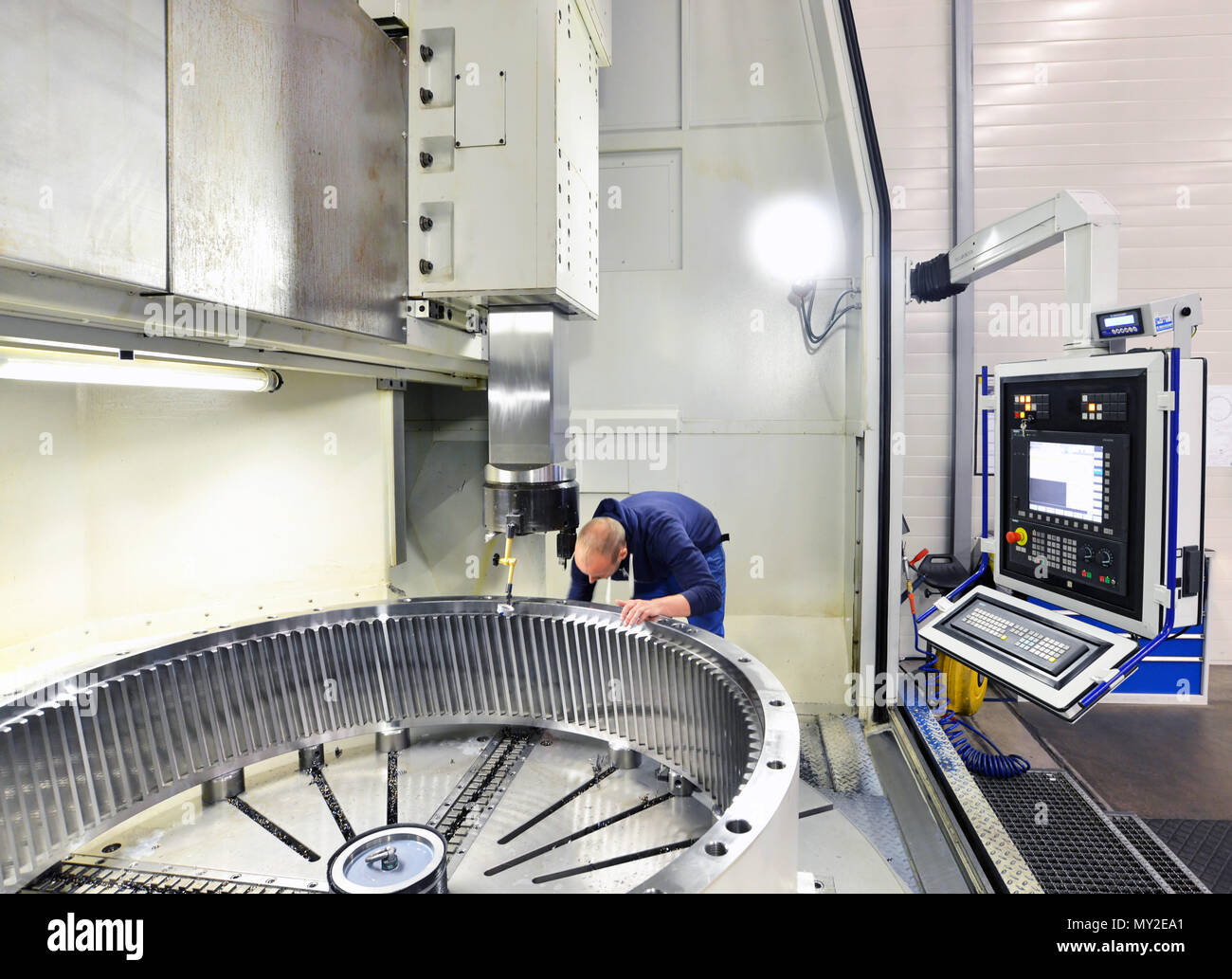 La fabbrica della moderna ingegneria meccanica - produzione di scatole per cambi di turbine eoliche - lavoratore in macchina CNC Foto Stock