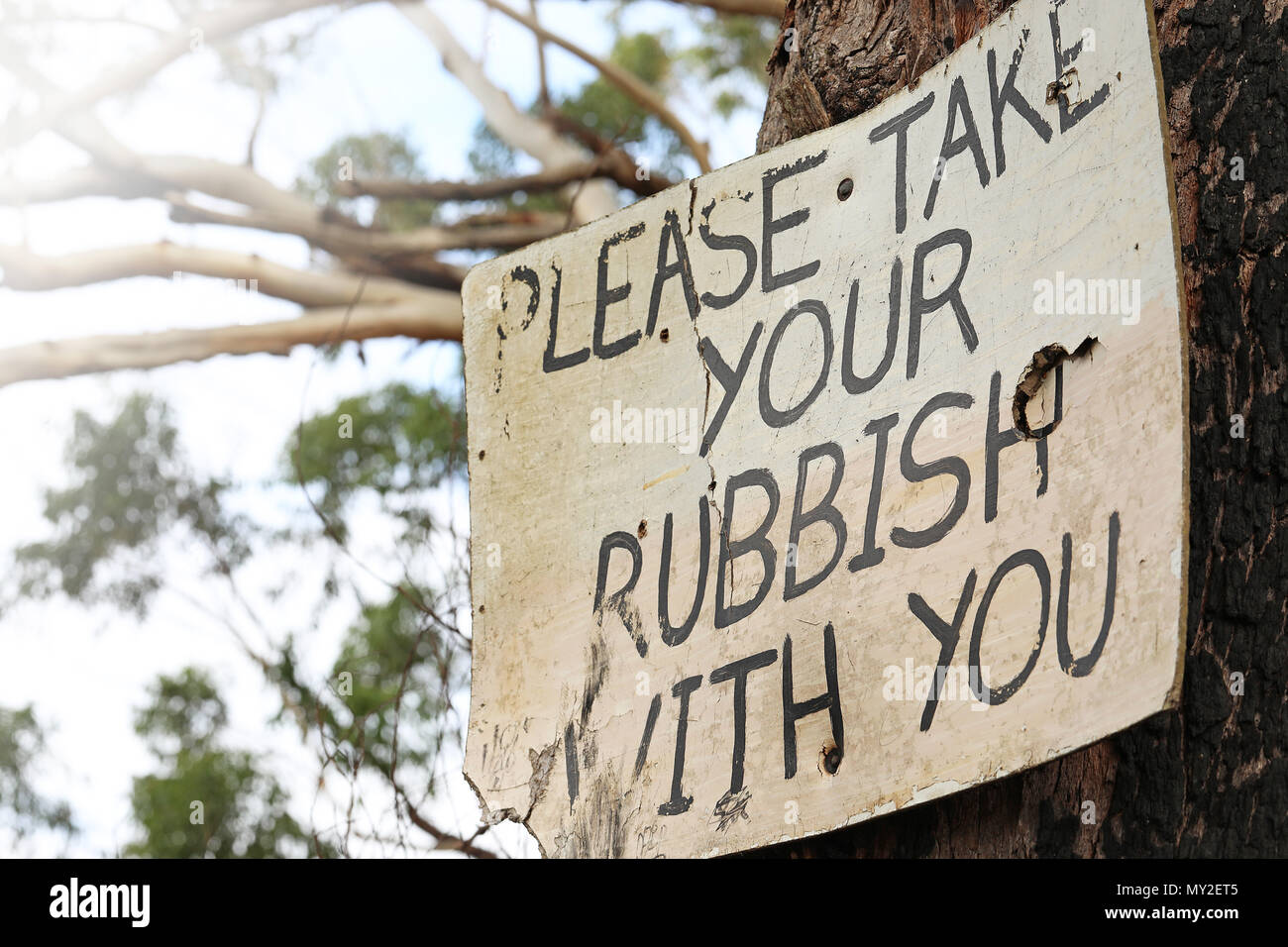 Più viste di un vecchio segno usurata post di istruire i partecipanti i pescatori bush camminatori escursionisti ad assumersi la responsabilità per la rimozione di tutti i rifiuti nel cestino della spazzatura Foto Stock