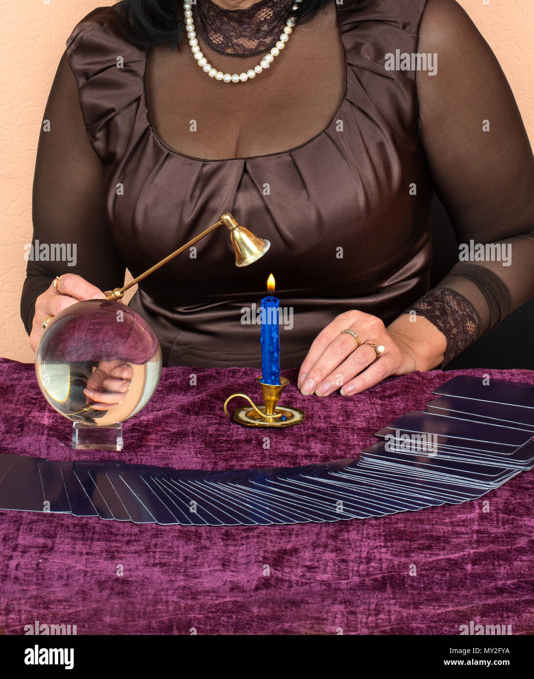 La donna mette fuori la candela dopo la divinazione sulle carte dei tarocchi Foto Stock