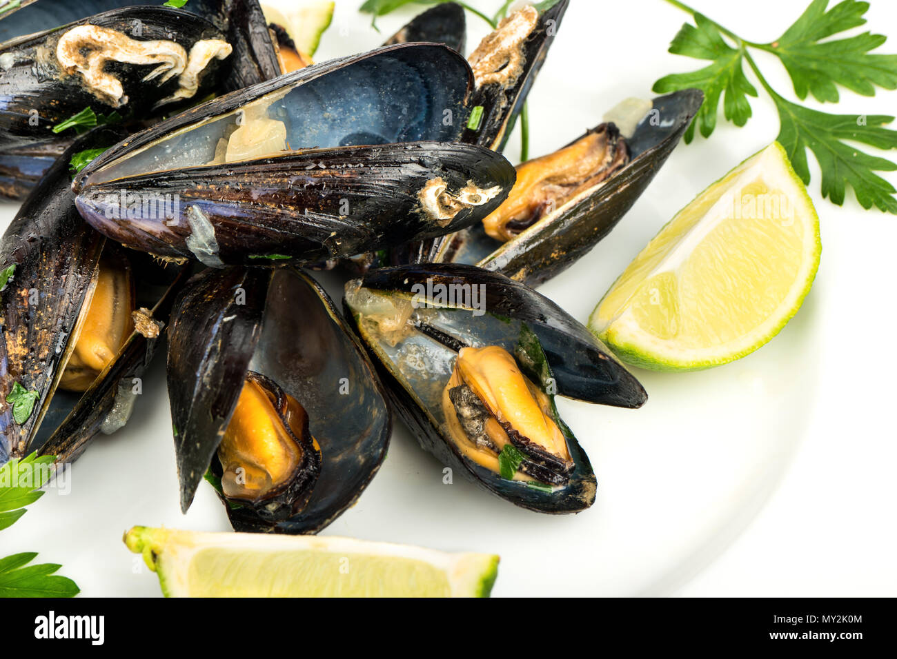 Delizioso preparato le cozze con calce su una piastra, close-up Foto Stock