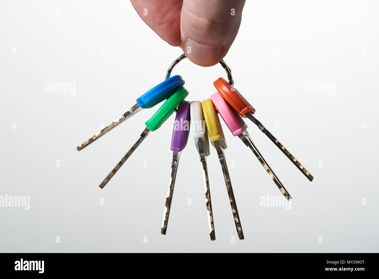 Metallo colorato tasti sul ring tenendo la mano vista da vicino Foto Stock