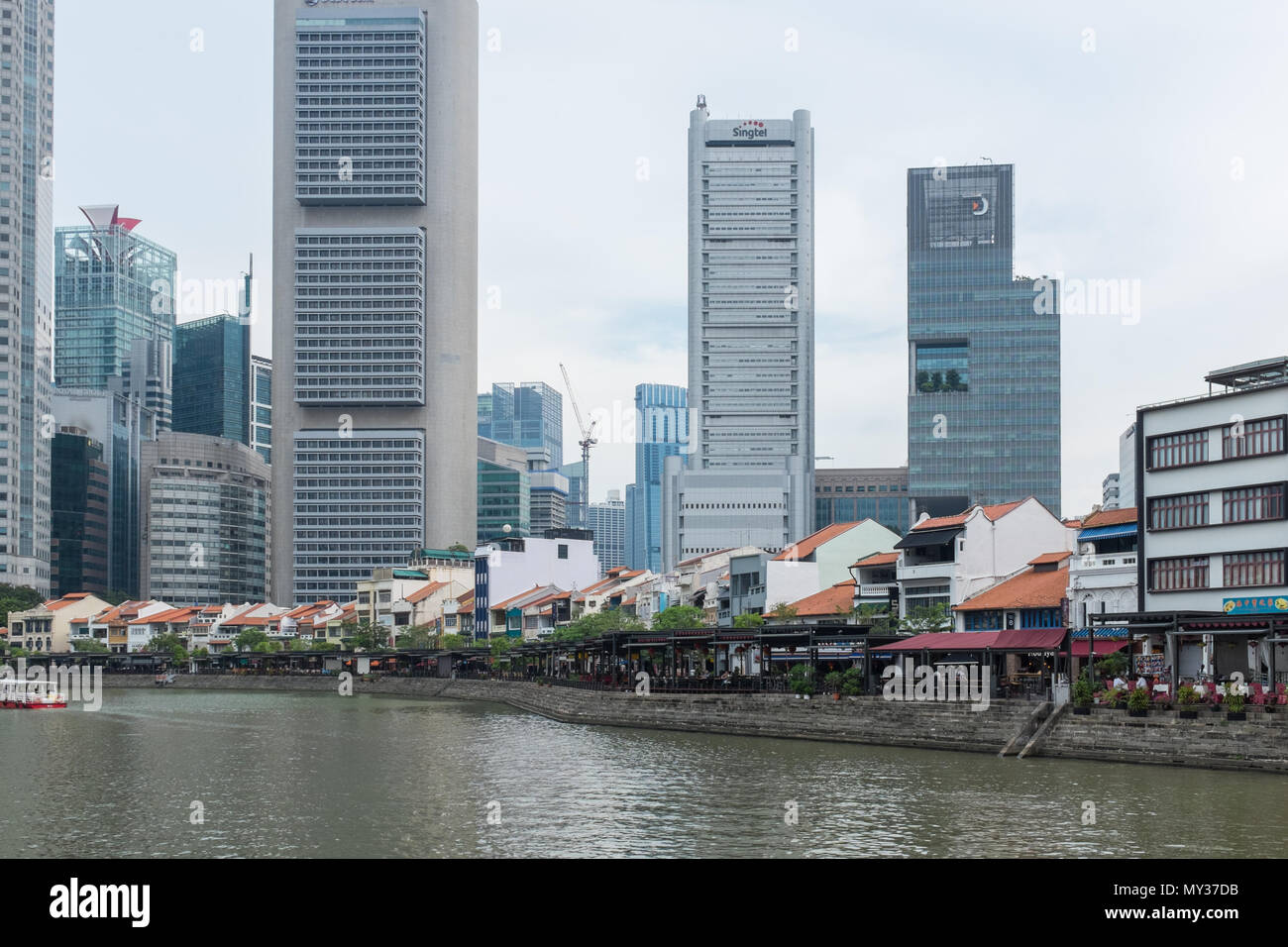 Bar e ristoranti la linea la banca del fiume Singapore al Boat Quay offuscato dall alto edifici per uffici dietro di loro. Foto Stock