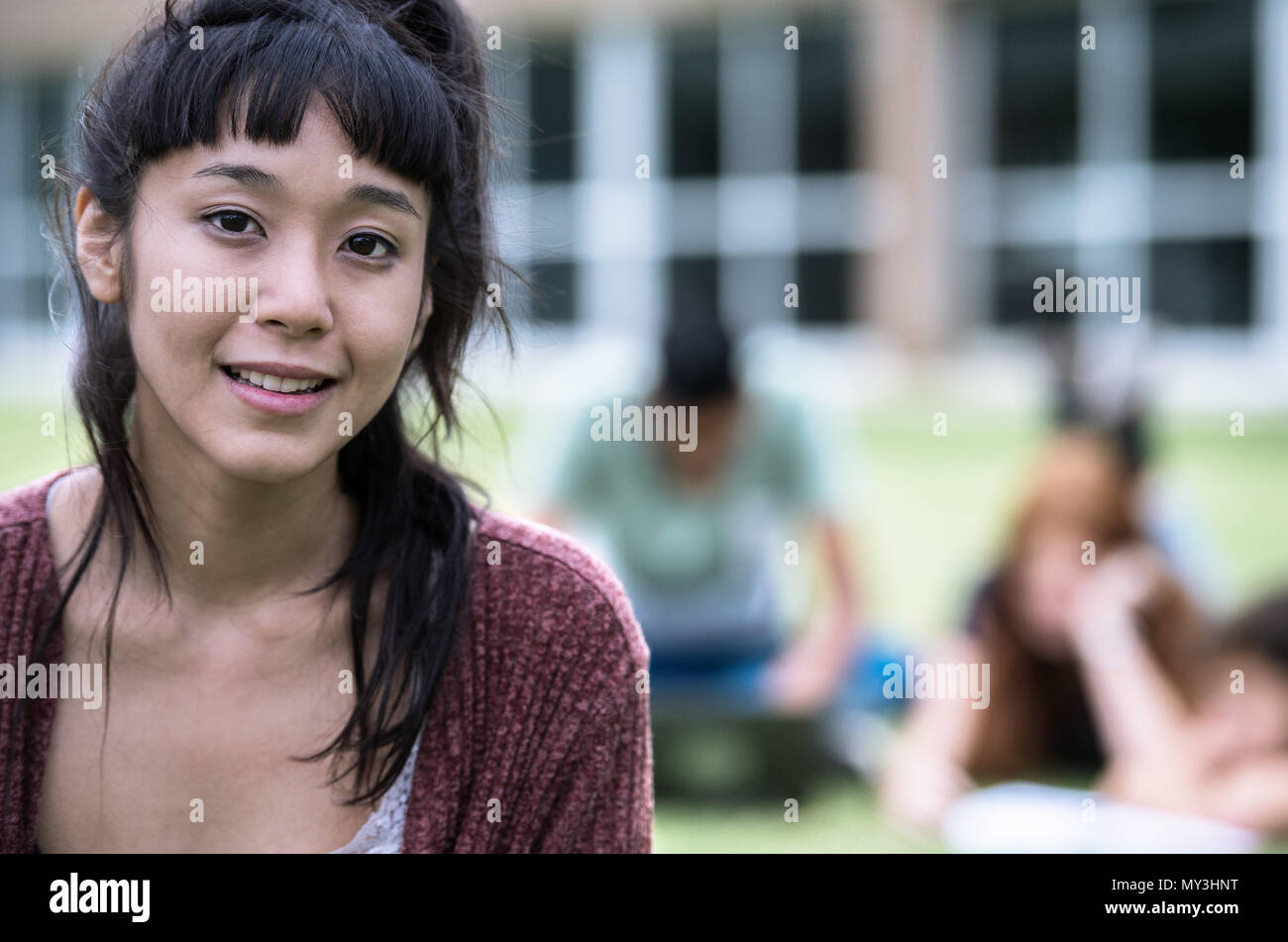 Giovane donna sorridente all'aperto, ritratto Foto Stock