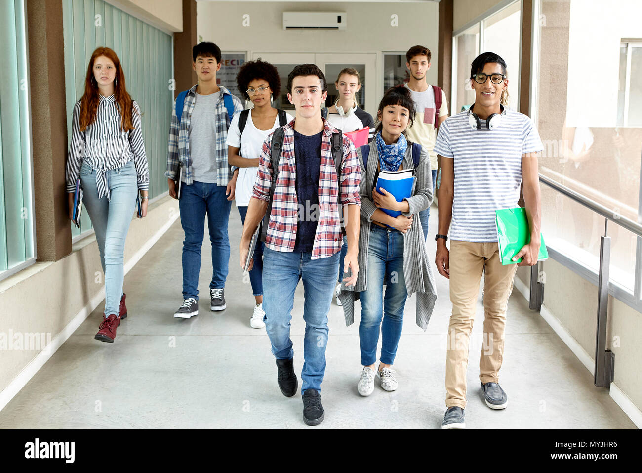 Gli studenti a piedi nel corridoio della scuola Foto Stock