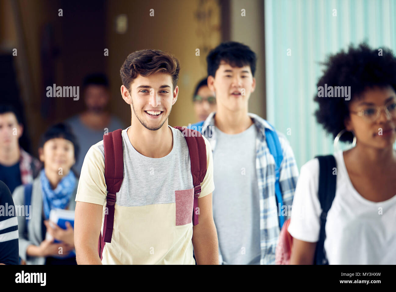 Studente di sorridere quando egli cammina tra le classi Foto Stock