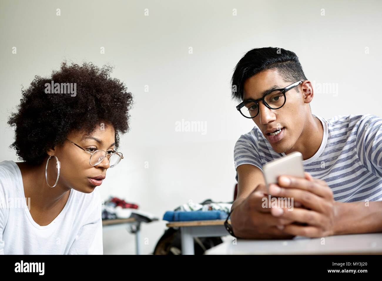 Lo studente che mostra classmate smart phone Foto Stock