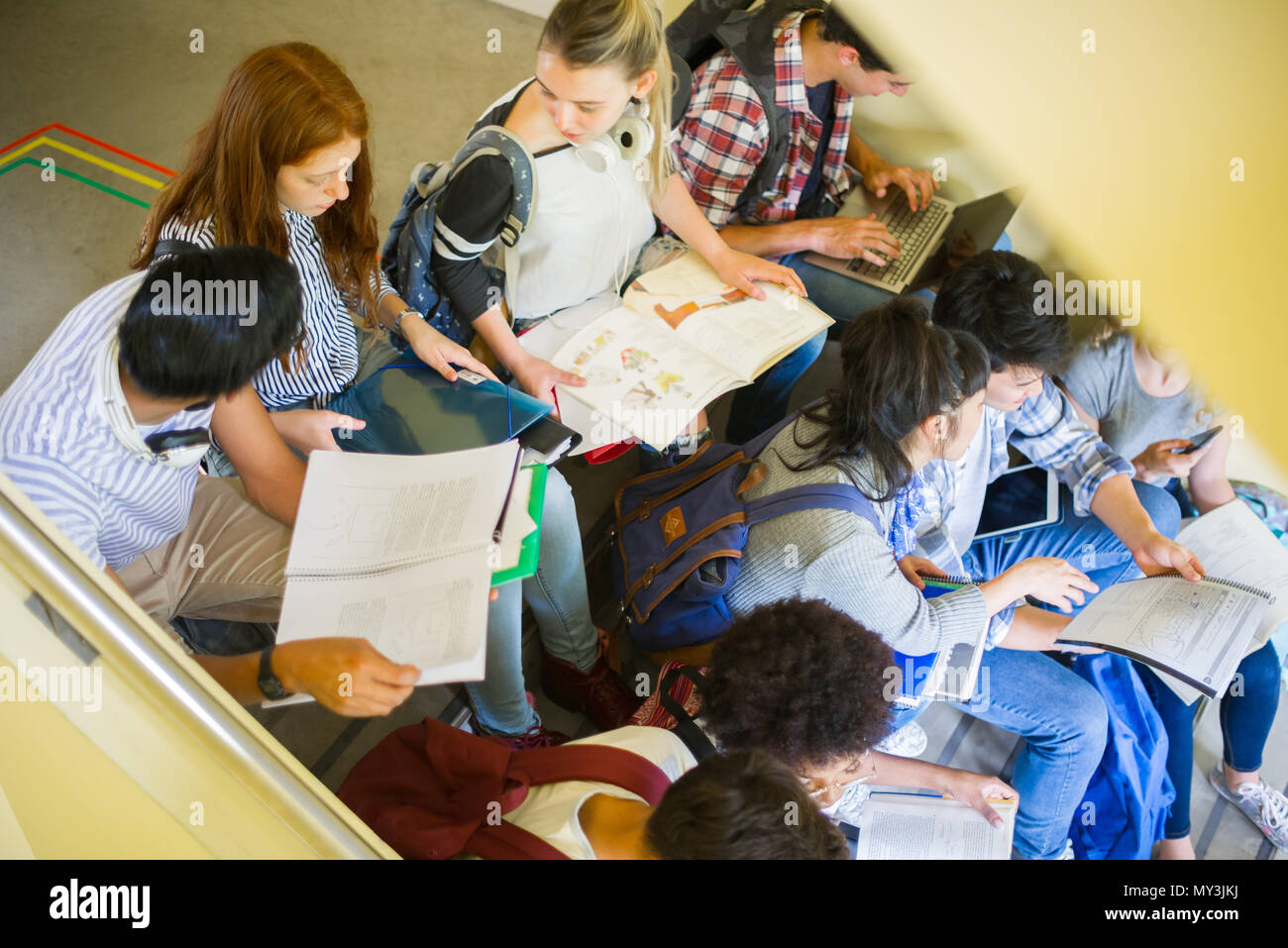 Gruppo di studenti che studiano insieme in scale Foto Stock