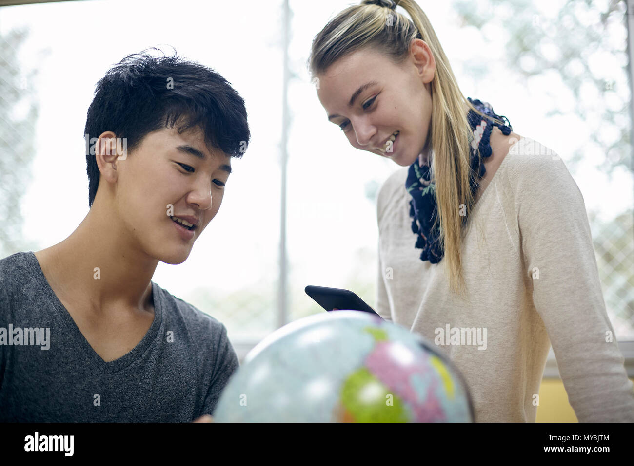 Gli studenti guardando il mondo in classe Foto Stock