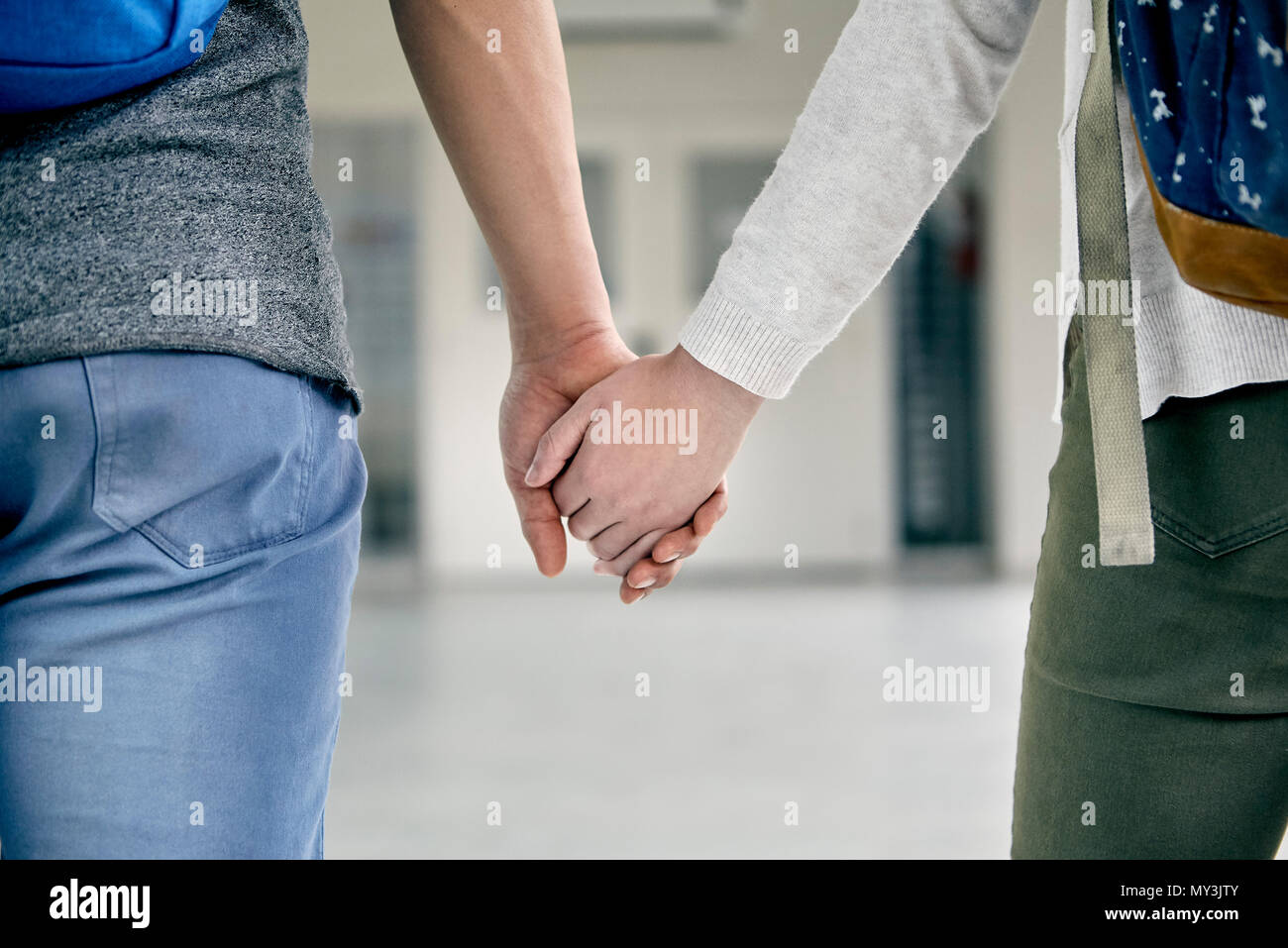 Giovane holding hands in corridoio, ritagliato Foto Stock