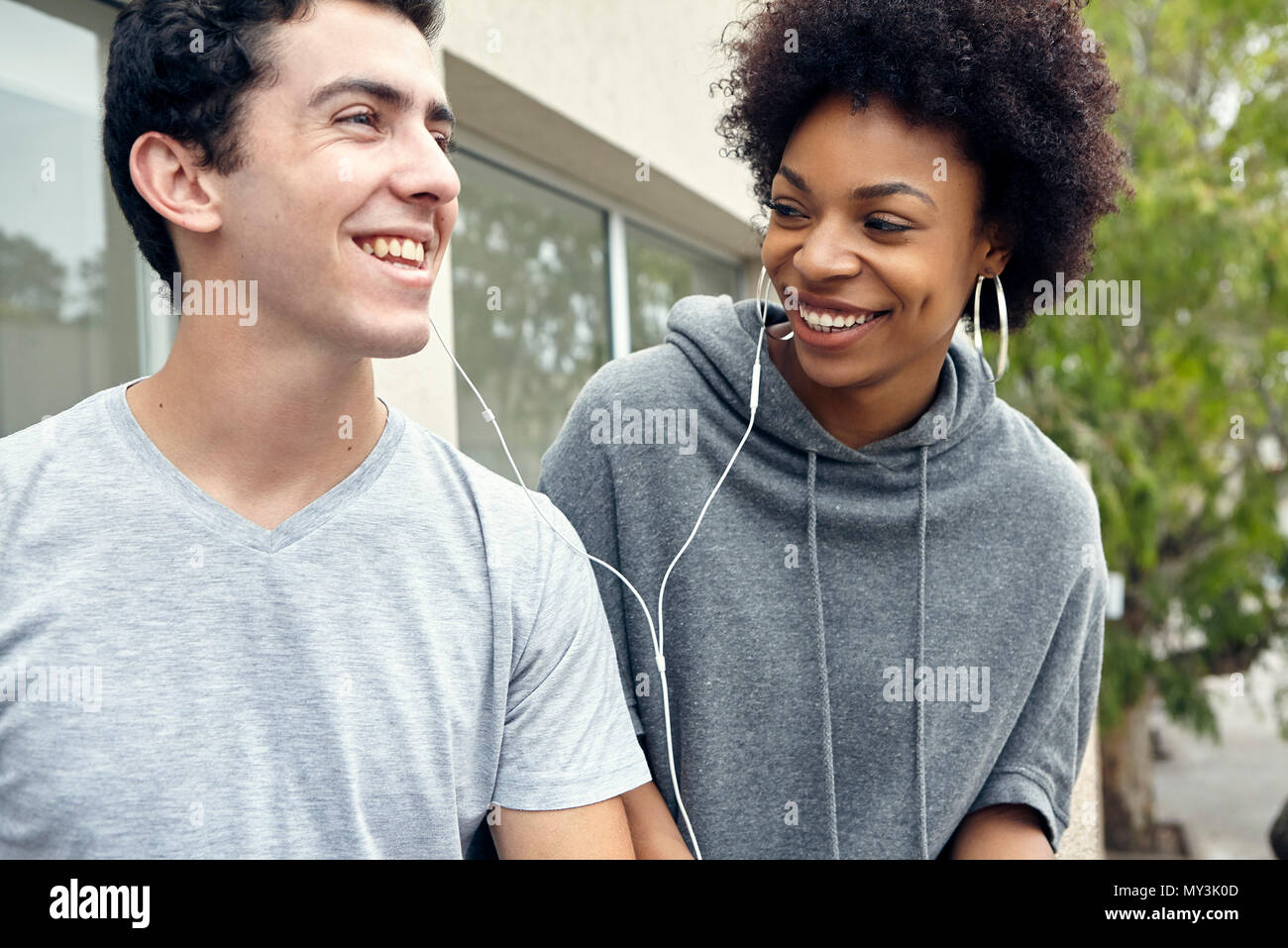 Coppia giovane ascoltando musica insieme con gli auricolari Foto Stock
