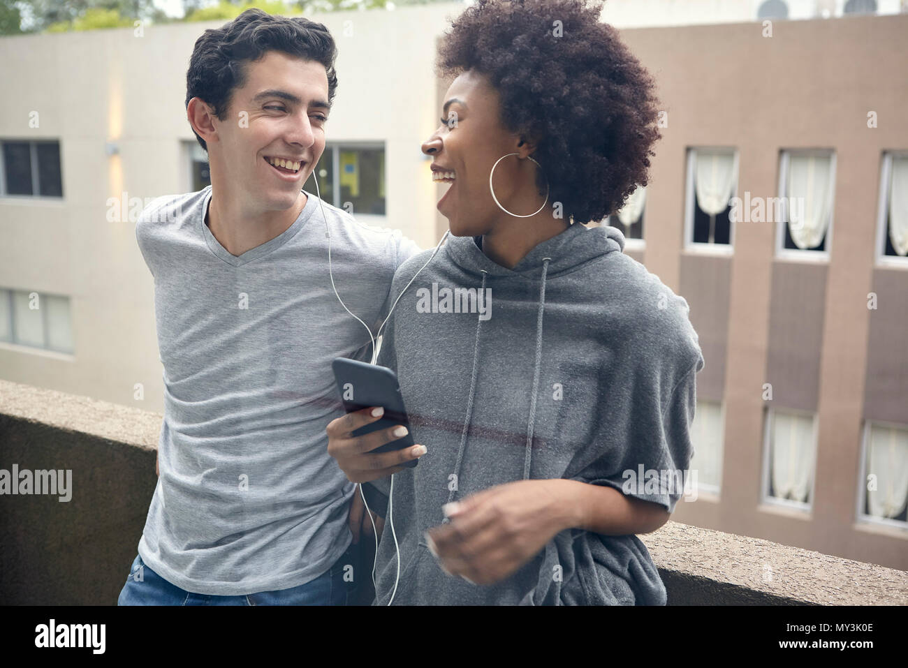 Coppia giovane ascoltando musica insieme su smart phone Foto Stock