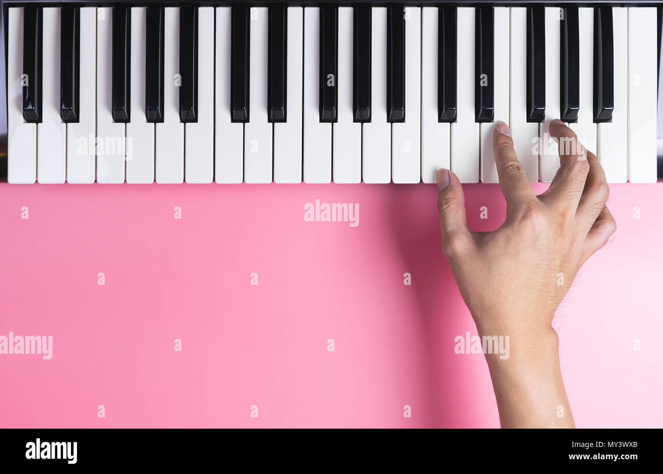 Tastiera a mano il giocatore sta giocando sulla tastiera con rosa spazio di copia Foto Stock