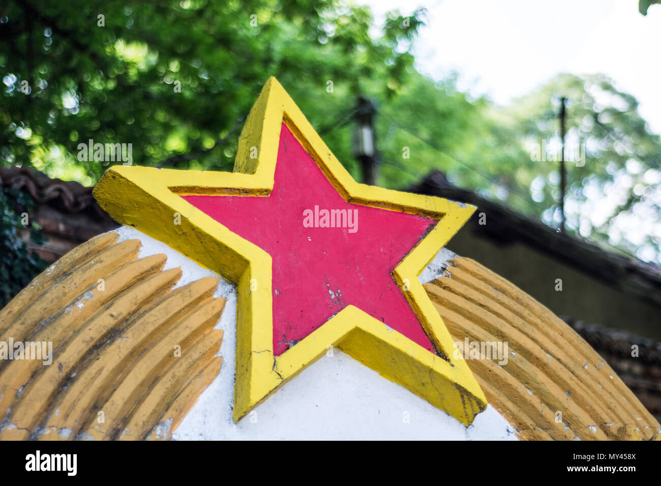 Nis, Serbia - Giugno 04, 2018: comunista stella rossa segno della ex Jugoslavia paese abbandonato nella struttura ad albero e di erba in natura Foto Stock