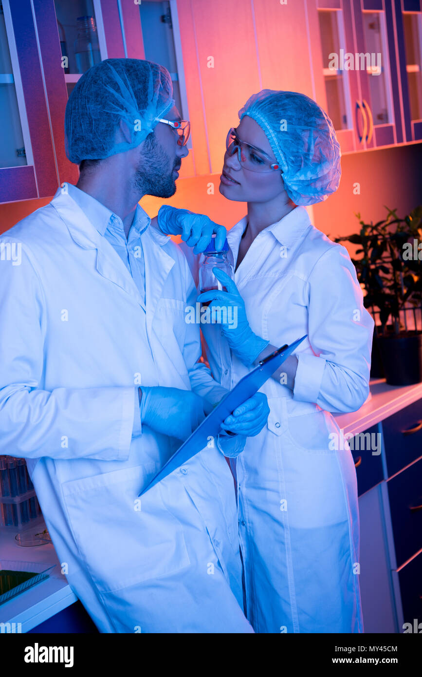Gli scienziati avente carica romanticismo al laboratorio durante il lavoro Foto Stock