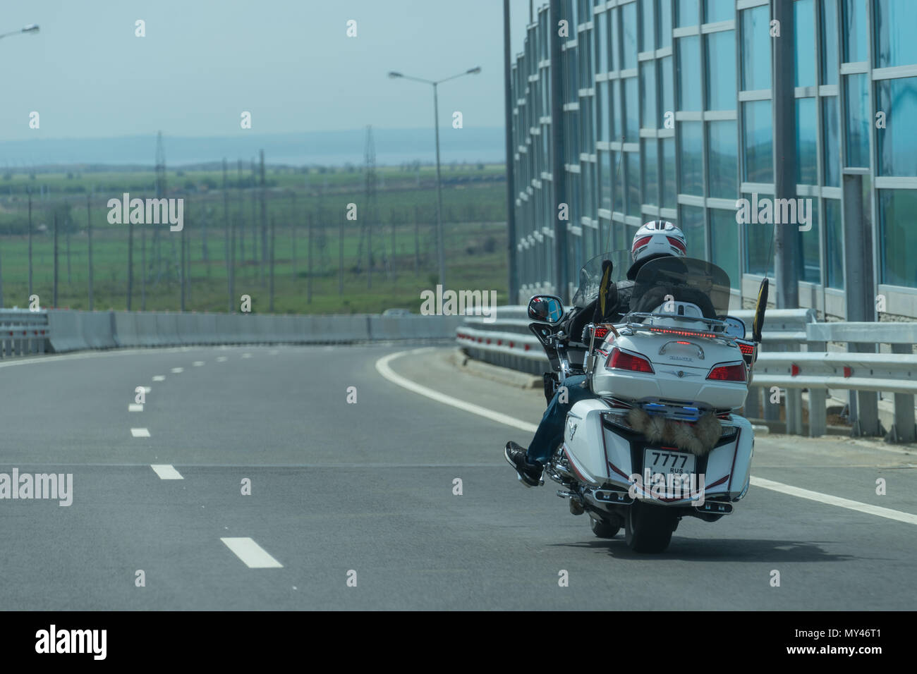 Regione Krasnodar, Russia - 19 maggio 2018: il pilota sul bianco moto racing in autostrada per il ponte di Crimea. Foto Stock