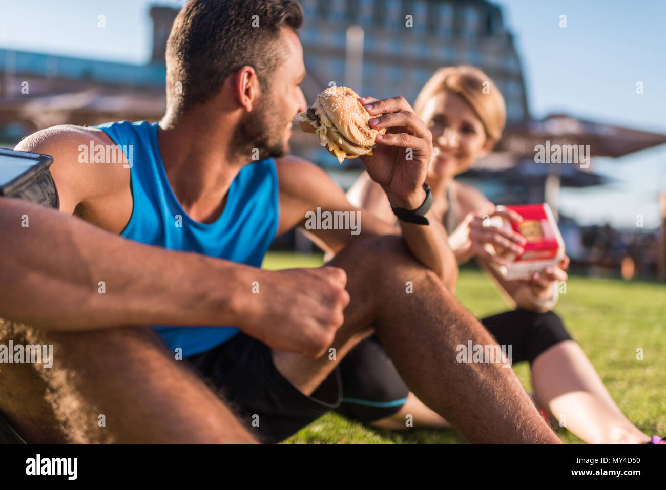 Athletic sportive e sportivo di mangiare cibo spazzatura Foto Stock