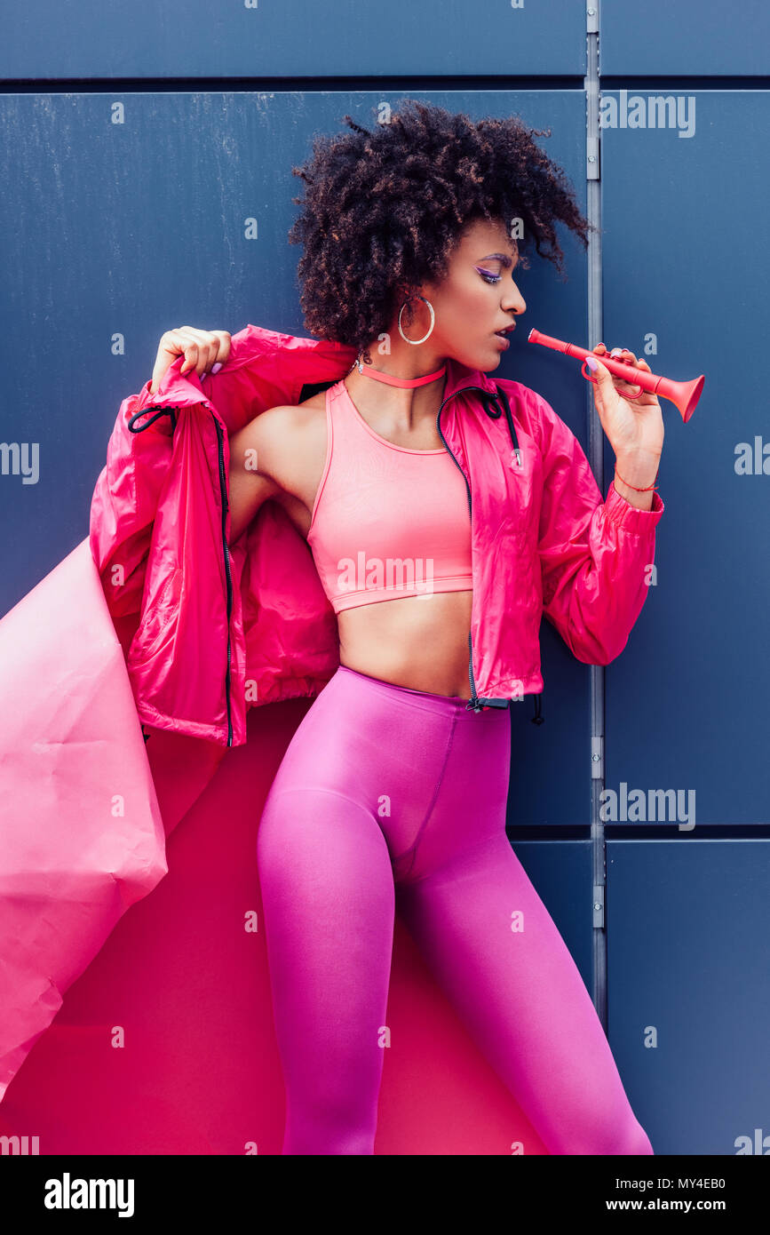 Moda African American Girl con tromba in posa di 80s vestiti in stile con la carta rosa Foto Stock