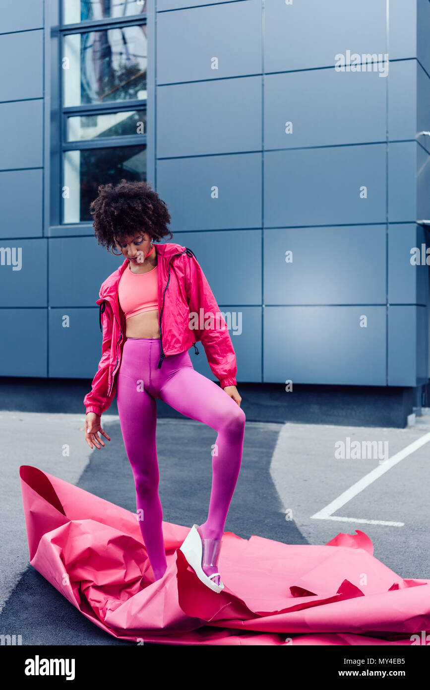 Moda African American Girl in posa di 80s vestiti in stile con la carta rosa Foto Stock