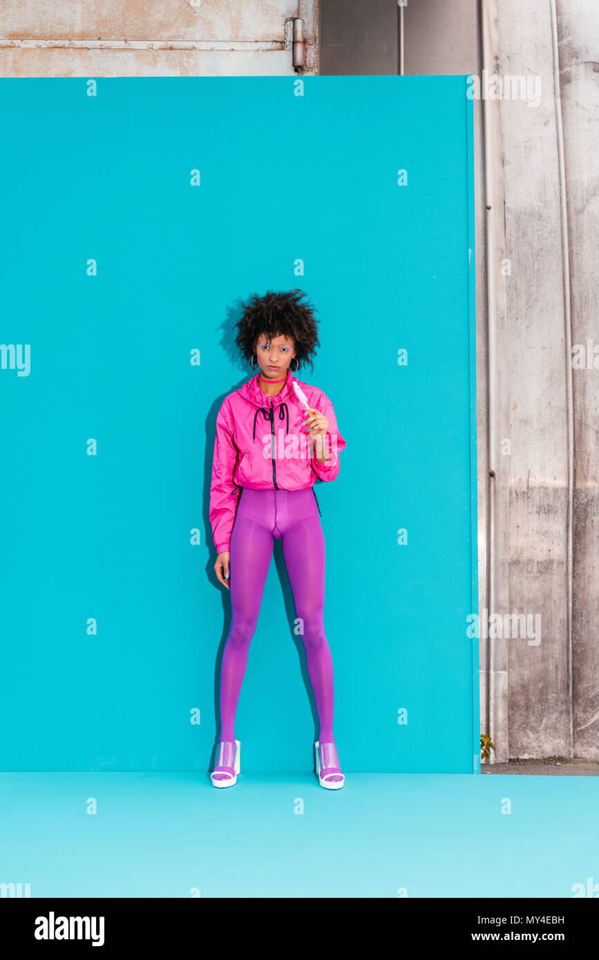 Moda African American Girl con ghiaccioli che pongono in 80s style vestiti sul turchese Foto Stock