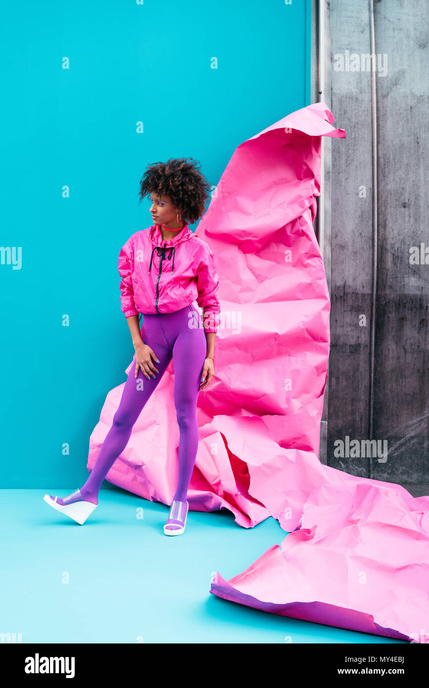 Moda African American Girl in posa di 80s style vestiti sul turchese con carta rosa Foto Stock