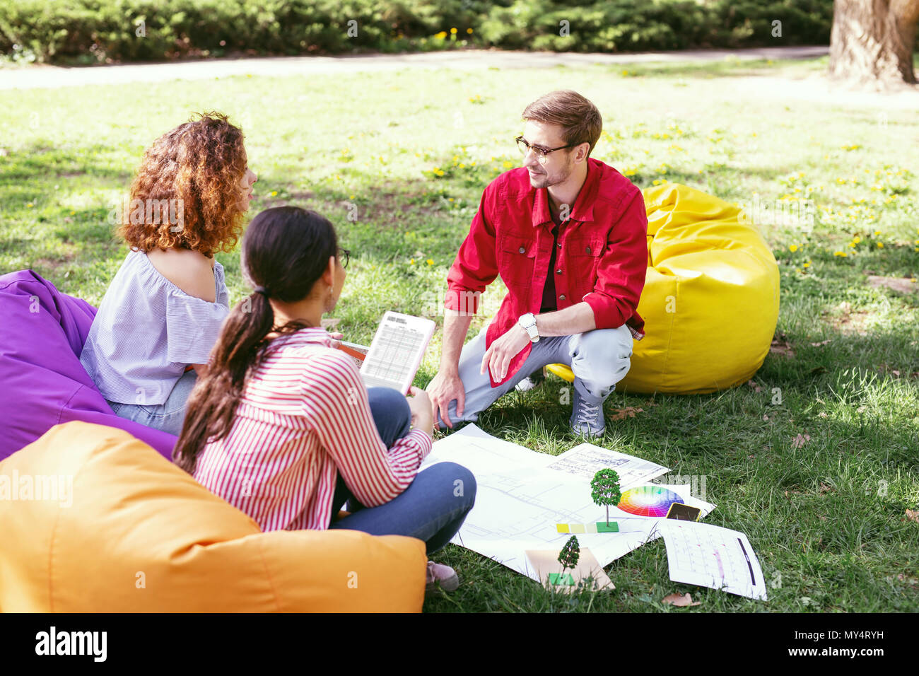 Datore di lavoro serio a discutere di un progetto con i suoi collaboratori Foto Stock