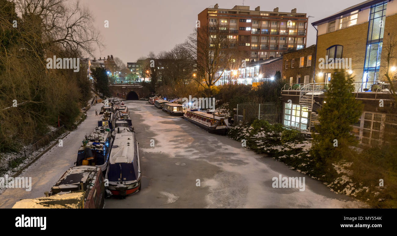 London, England, Regno Unito - 1 Marzo 2018: Canal barche sono ormeggiate in acque congelate del Regent's Canal, accanto a una coperta di neve alzaia a Londra il re Foto Stock