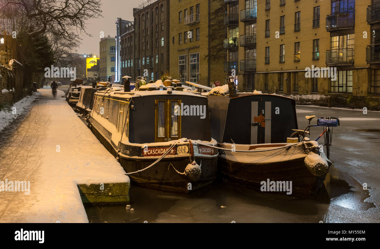 London, England, Regno Unito - 2 Marzo 2018: Canal barche sono ormeggiate in acque congelate del Regent's Canal, accanto a una coperta di neve alzaia a Londra il re Foto Stock