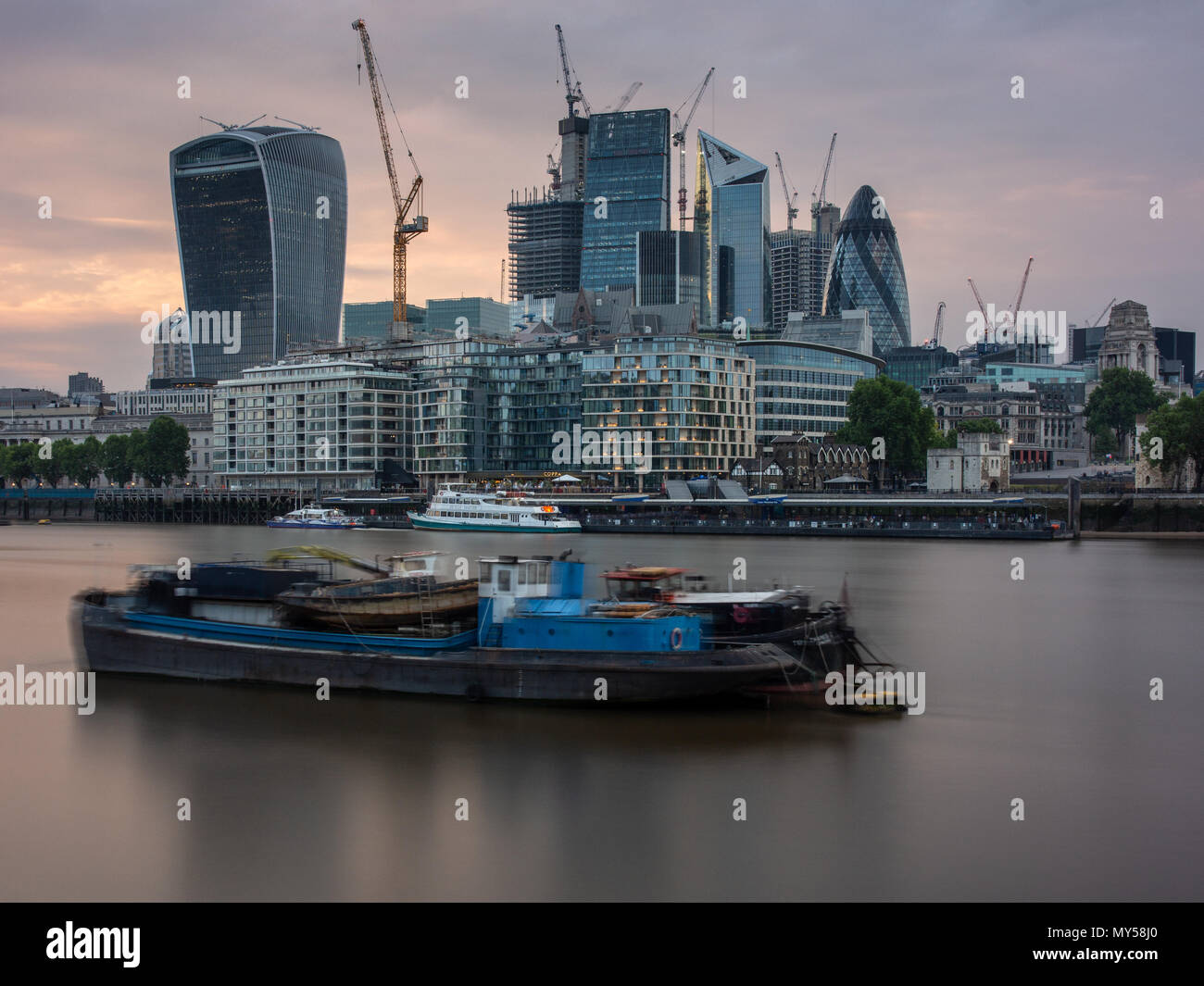 London, England, Regno Unito - 1 Giugno 2018: grattacieli sono circondati con gru durante un boom edilizio nella città di Londra, con barconi nel fiume Foto Stock