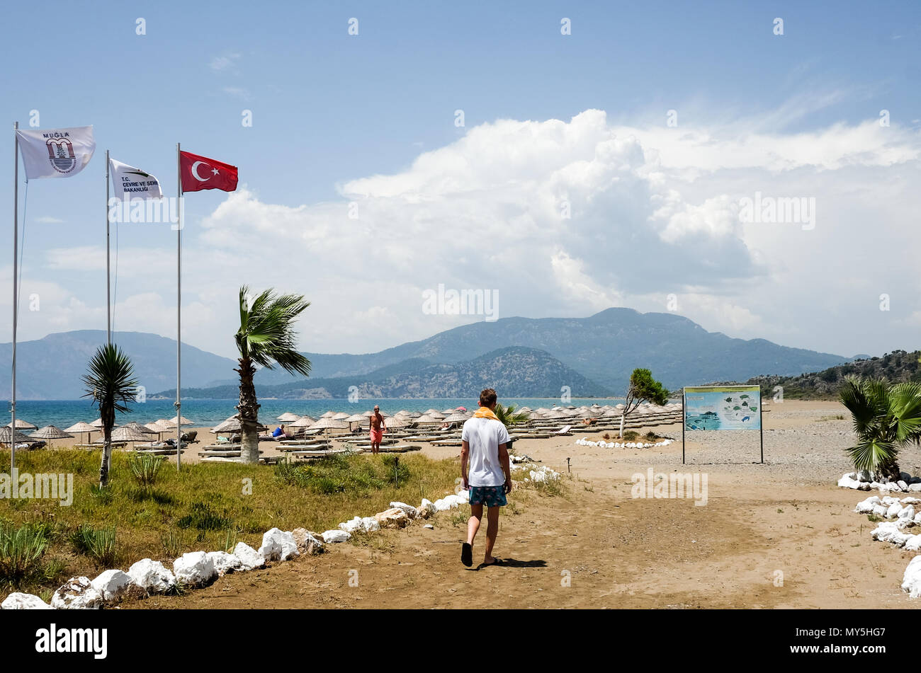 25.05.2018, Dalyan, Turchia: una bandiera turca sta soffiando sul vuoto Iztuzu beach. La spiaggia di Iztuzu è situato in una riserva naturale. Questo è il punto in cui il falco sbagliato tartaruga di mare (Caretta caretta) depone le uova. Foto: Jens Kalaene/dpa immagine centrale/dpa | Utilizzo di tutto il mondo Foto Stock