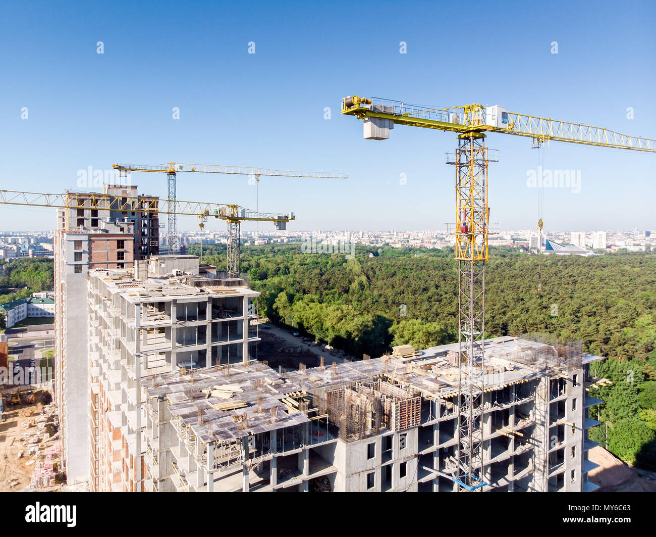 Vista aerea del cantiere con gru gialle e multi-piani edificio residenziale Foto Stock