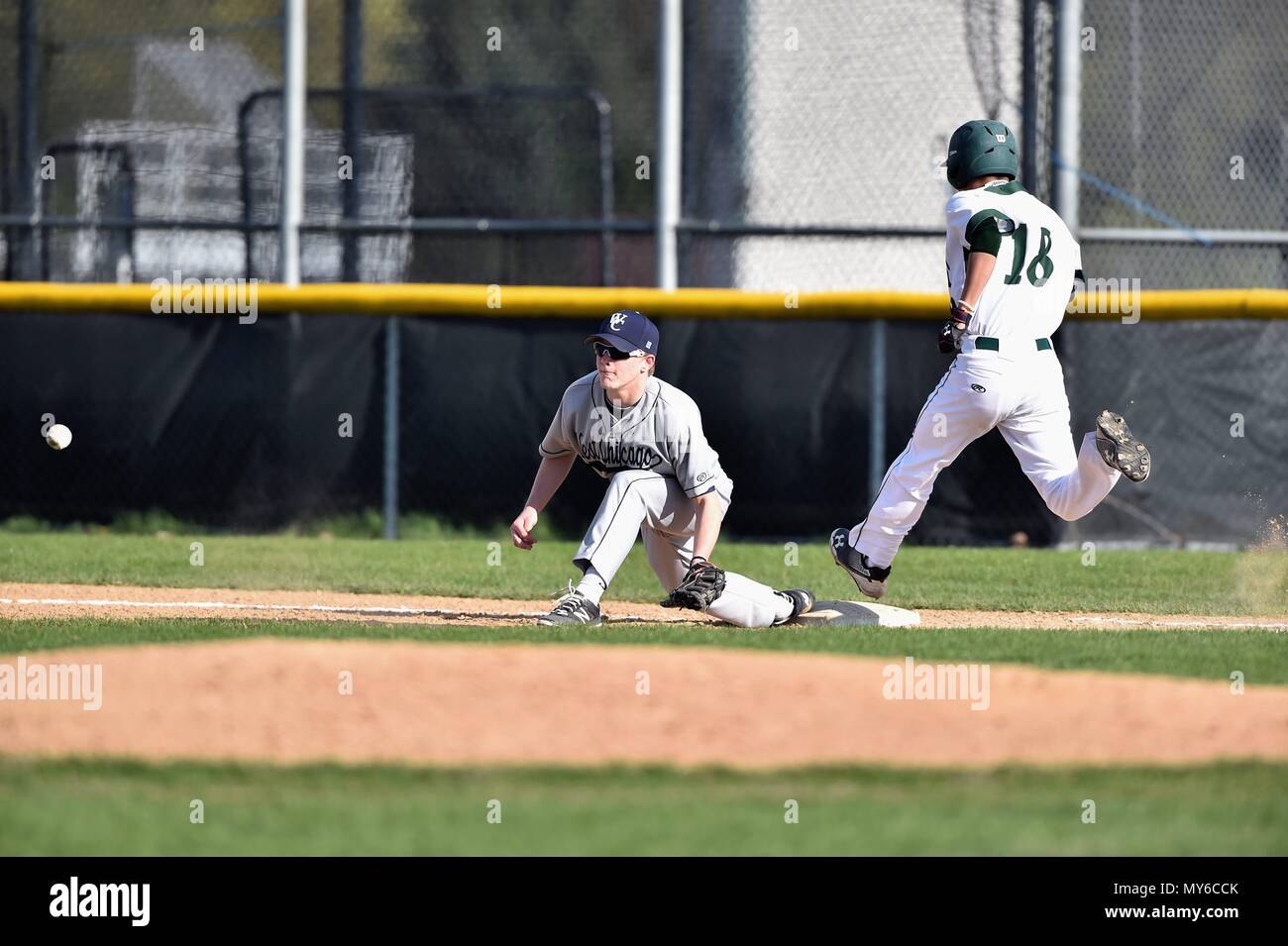 Pastella/runner battendo un infield hit come i contrapposti primo baseman teso a campo a tardy buttare. Stati Uniti d'America. Foto Stock