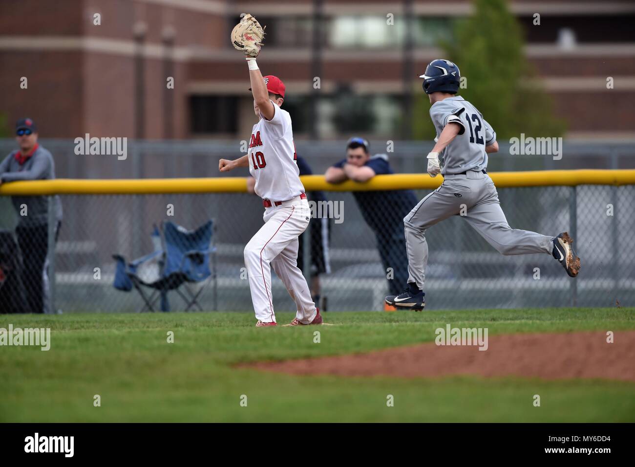 Primo baseman stretching per prendere un tramite di tutta l'infield a ritirare il hitter sul gioco. Stati Uniti d'America. Foto Stock