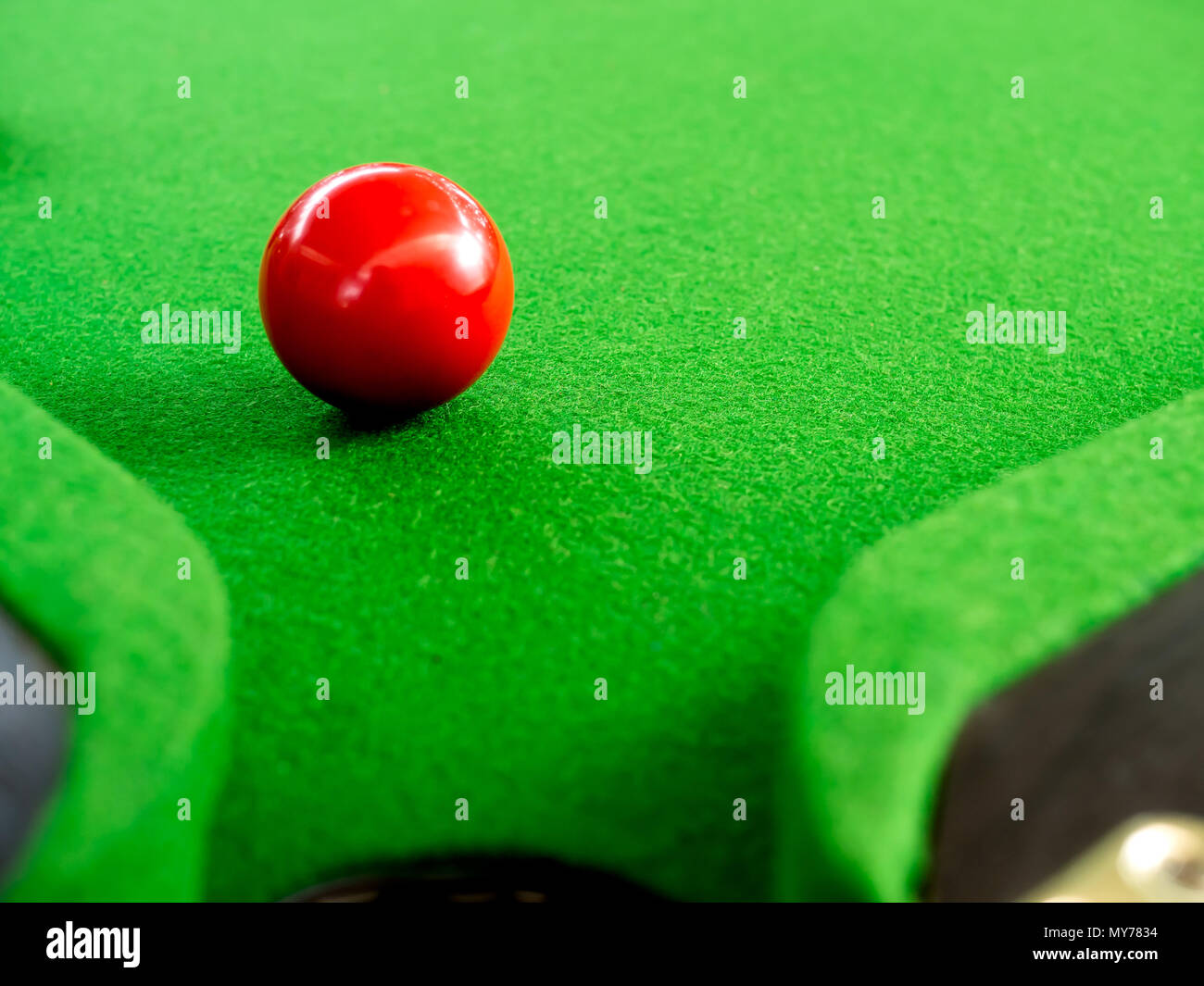 Red Snooker palla vicino foro d'angolo sul verde Tavolo da biliardo Foto Stock