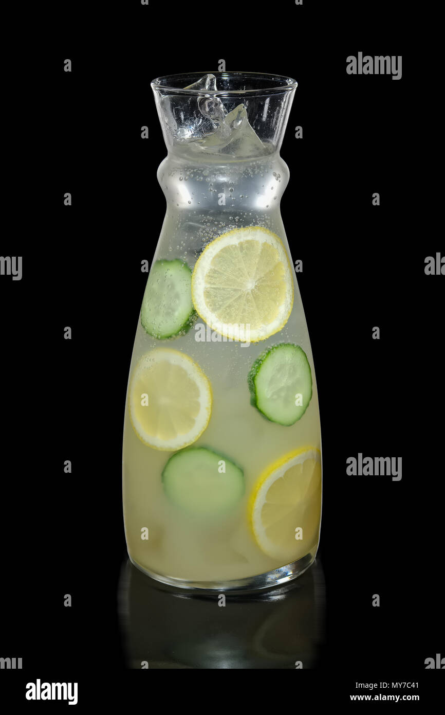 Decanter con limone e cetriolo limonata isolato su nero Foto Stock