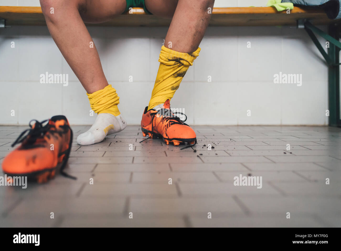 Giocatore di calcio in una scarpa da calcio in spogliatoio Foto Stock
