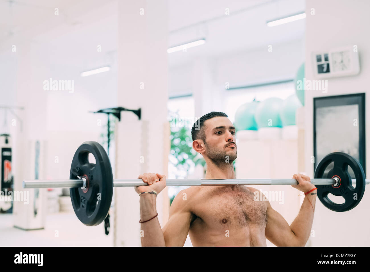 Uomo di sollevamento pesi usando barbell Foto Stock